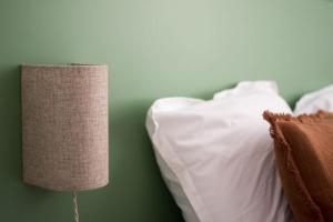 a lamp sitting next to a bed with white pillows at Brune, Clim - Ultra Central in Arles +18 photos