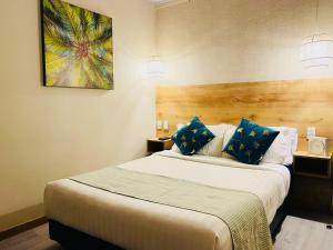 Habitación de hotel con cama grande con almohadas azules en Di House Apart - Habitacion Privada en San Andrés