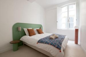 a bed with a green headboard in a bedroom at Brune, Clim - Ultra Central in Arles