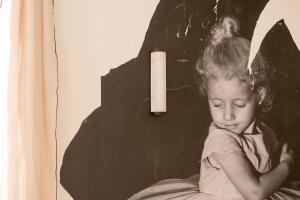 an old photo of a little girl sitting on a bed at Brune, Clim - Ultra Central in Arles