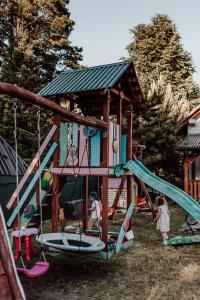 un niño jugando en un parque infantil con un tobogán en Domki RADAWA na Kliszówce, en Radawa