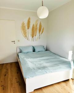 ein Schlafzimmer mit einem Bett mit blauer Bettwäsche und einem Gemälde an der Wand in der Unterkunft Die Ibbenbürener Ferienstube in Ibbenbüren