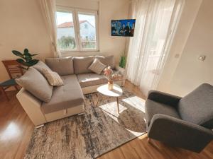 a living room with a couch and a table at Beach Apartment x2 Bedrooms w Sea View & 2x En-Suites in Šibenik