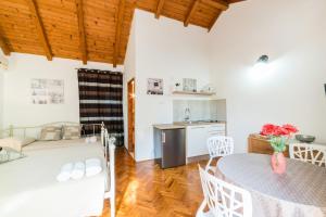 un soggiorno con tavolo e cucina di Apartmani Bugenvilija a Brbinj