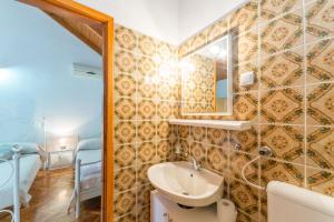a bathroom with a sink and a mirror at Apartmani Bugenvilija in Brbinj
