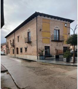 a brick building with windows and balconies on a street at Hotel Restaurante Doña Elvira in Nava del Rey