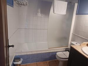 a bathroom with a white tub and a toilet at Hotel Restaurante Doña Elvira in Nava del Rey