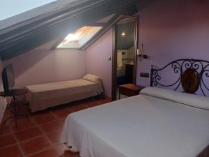 a bedroom with a white bed and a mirror at Hotel Restaurante Doña Elvira in Nava del Rey