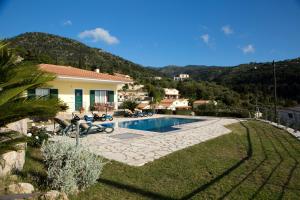 a house with a swimming pool in a yard at PANTHEON RESORT AND VILLAS in Agios Nikitas