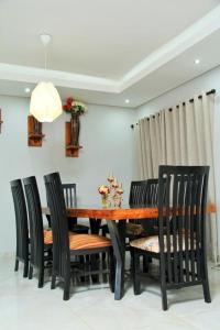 a dining room with a wooden table and chairs at Tlokweng Rose Garden Guesthouse in Gaborone