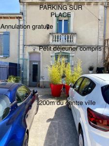 twee auto's geparkeerd voor een gebouw bij Côté Court in LʼIsle-sur-la-Sorgue
