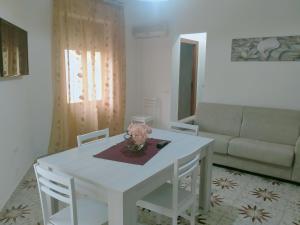 un tavolo bianco e sedie in soggiorno di Le Camelie appartamento a Bosa