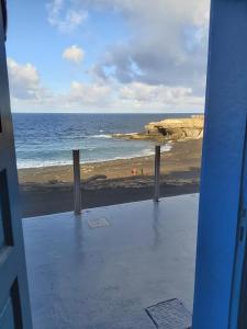 een uitzicht op een strand vanaf een deuropening bij Ajuy apartament Seafront&quiet in Ajuy