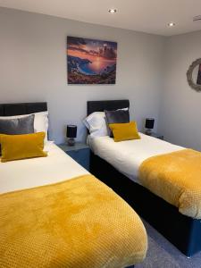 two beds sitting next to each other in a room at The Penthouse - Luxury 2 Bed Apartment in Skegness