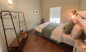 a bedroom with a bed and a ladder at The Green Heart Inn in Kingsville