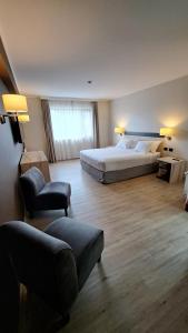 - une chambre avec un lit, un canapé et une chaise dans l'établissement Hotel Diego de Almagro Castro, à Castro