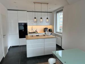 cocina con armarios blancos y encimera en Lovely HOME Suite in Nuremberg, en Núremberg