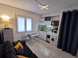 a living room with a couch and a kitchen at Appartement Le Mistral in Balaruc-les-Bains