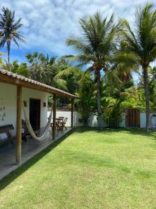 a backyard with a hammock and palm trees at La belle de jour in Fortim