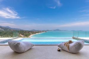two bean bag chairs sitting on the floor next to a swimming pool at Villa Anushka - Modern luxury villa with picture-perfect sea views in Koh Samui 