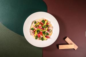 un bol blanc de nourriture avec des légumes sur une table dans l'établissement Hotel Starc by Pierre & Vacances Premium, à Andorre-la-Vieille