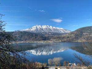 a view of a lake with a snow covered mountain at Hotel Monte Cimone in Caldonazzo