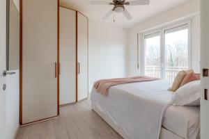 - une chambre blanche avec un lit et une fenêtre dans l'établissement Casa Martina, à Castelletto sopra Ticino
