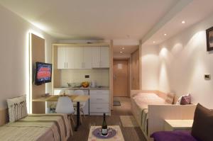 科帕奧尼克的住宿－Konaci Kopaonik Lux Apartmani，一间带一张床和一张书桌的卧室和一间厨房