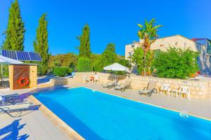 a swimming pool with chairs and umbrellas at Villa Georgios Rafaela in Polis Chrysochous