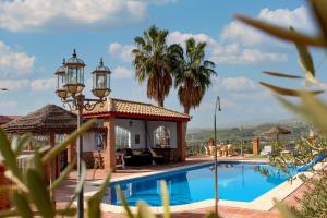 a villa with a swimming pool and a gazebo at Casa Rural Caminito del Rey in Alora