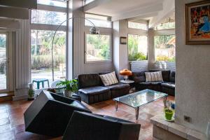 a living room with couches and a glass table at Le Clos de Gally in Chavenay