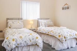 A bed or beds in a room at Fabulous detached lodge with hot tub two nights minimum stay