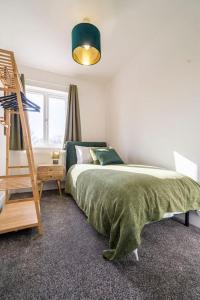 ein Schlafzimmer mit einem Bett mit einer grünen Decke in der Unterkunft Ansley house in Arley