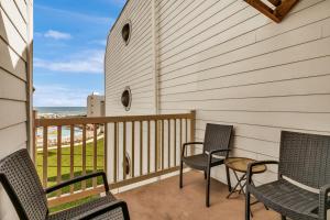 a balcony with two chairs and a table on it at Ocean view with easy beach access in South Padre Island