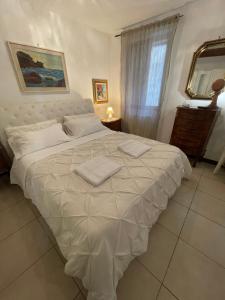 een slaapkamer met een groot wit bed en 2 handdoeken bij Charme Holidays Venice in Venetië