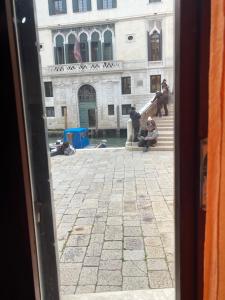 een persoon die op de trappen van een gebouw zit bij Charme Holidays Venice in Venetië