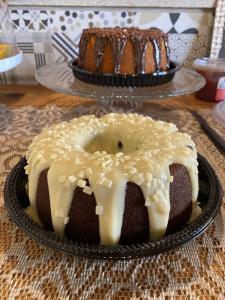 a bundt cake with icing on a plate next to a cake at Pousada Lótus in Chapada dos Guimarães