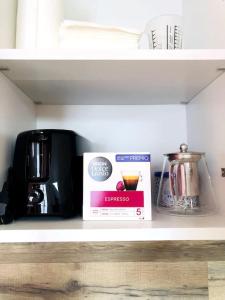 a kitchen shelf with a box and a coffee maker at Joli T2 en centre-ville de Rochefort in Rochefort