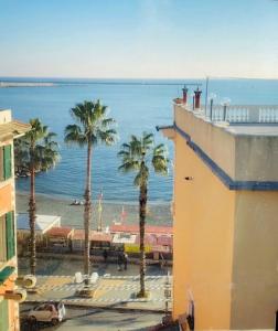 a view of a beach with palm trees and a building at La Finestra Sull’Oasi in Genoa