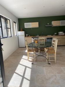uma sala de jantar com uma mesa e cadeiras numa cozinha em Maison dans la pinède em Rognes