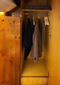 a closet with a wooden cabinet and a robe at La Finestra Sull’Oasi in Genoa