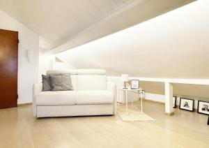 a white couch in a living room with a table at La Finestra Sull’Oasi in Genoa