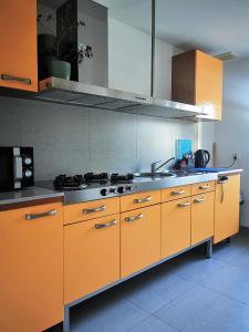 kuchnia z pomarańczowymi szafkami i kuchenką w obiekcie Hostel 55 - darmowy parking we Wrocławiu