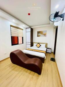 1 dormitorio con cama grande y sofá marrón en A&EM VILLA - 133 Tam Khương - by Bay Luxury, en Hanói