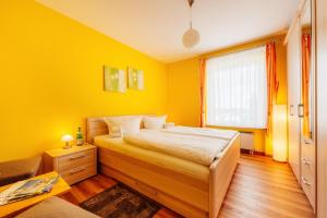 ブラウンラーゲにあるFerienwohnung Landgrafの黄色のベッドルーム(ベッド1台、窓付)