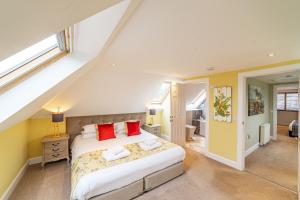 a bedroom with a bed with red pillows at Mill House with Hot Tub in Cray