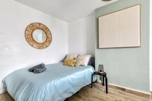 1 dormitorio con 1 cama con espejo en la pared en les Bulles Occitanes - tout à pied en Carcassonne