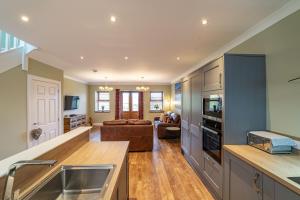 a kitchen with a sink and a living room at Mill House with Hot Tub in Cray