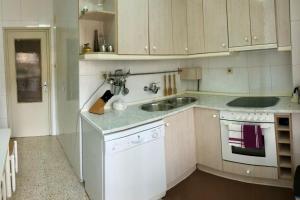 a white kitchen with a sink and a stove at Apartamento “Las Calmas” en Huesca in Huesca