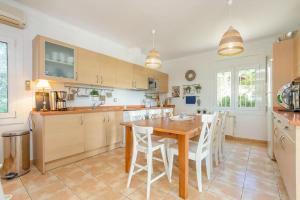 a kitchen with a wooden table and white chairs at V022 - VILLA ELS OLIVARS in Pau